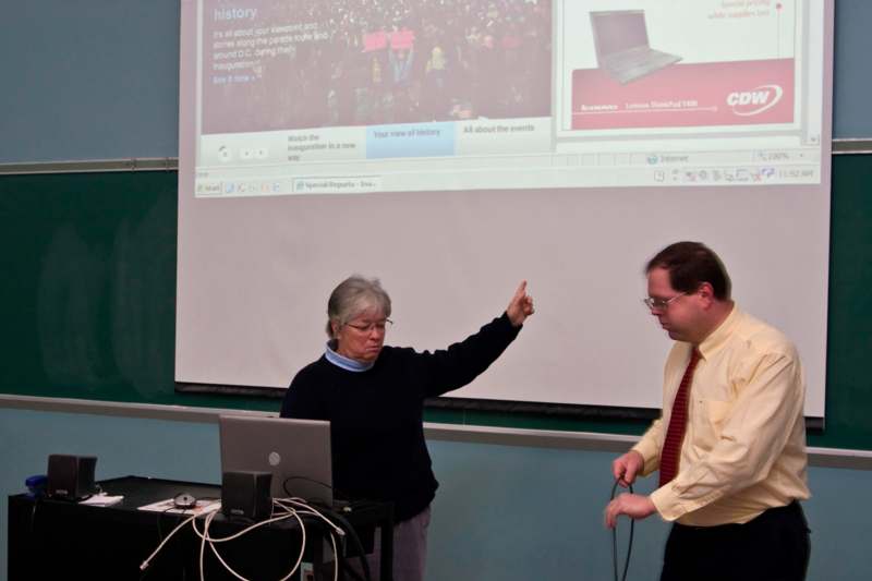 a man and woman standing in front of a projector screen