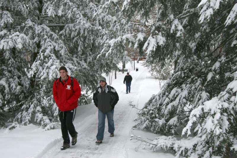 a group of men walking on a snowy path