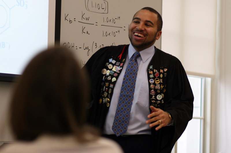 a man in a black robe with pins on his jacket