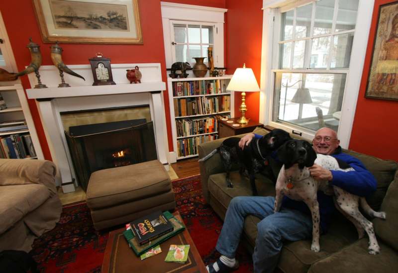 a man sitting on a couch with dogs