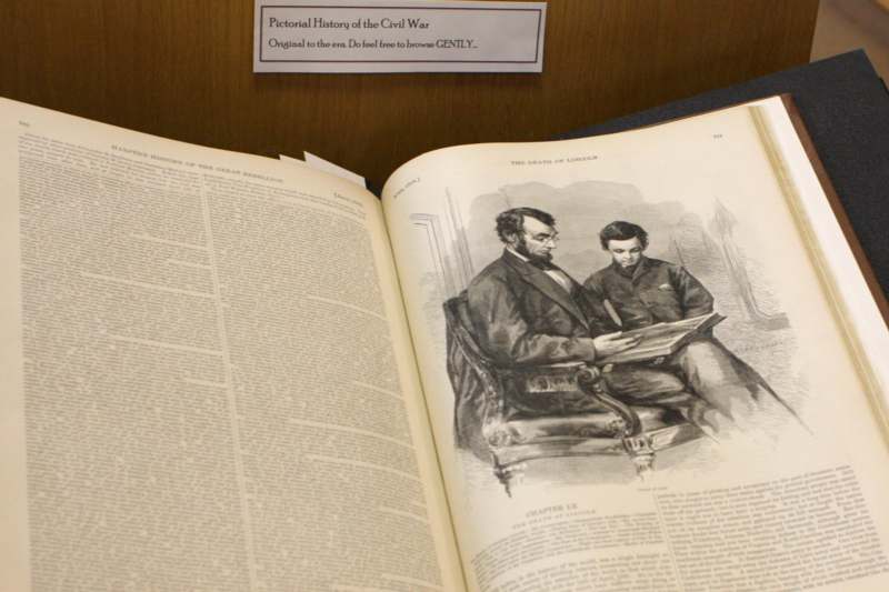 an open book with a picture of two men sitting on a chair