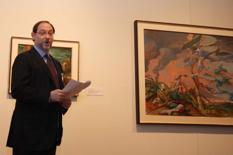 a man in a suit standing next to a painting