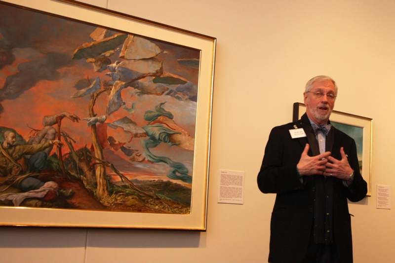 a man standing next to a painting