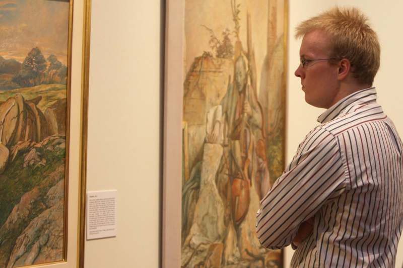 a man looking at a painting