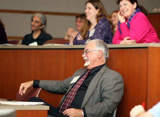 a man laughing at a lecture