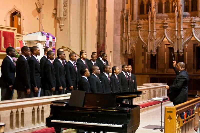 a group of men in suits singing in a church