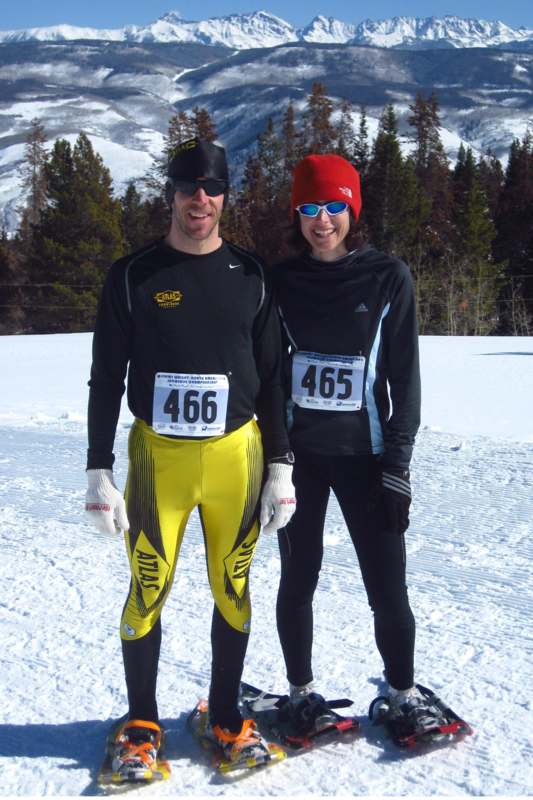 a man and woman in ski gear standing in snow