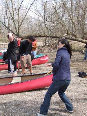 a group of people standing next to canoes
