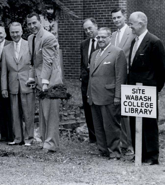 a group of men standing next to a sign