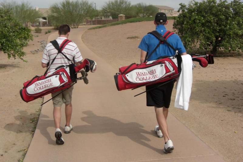 a group of men carrying golf clubs