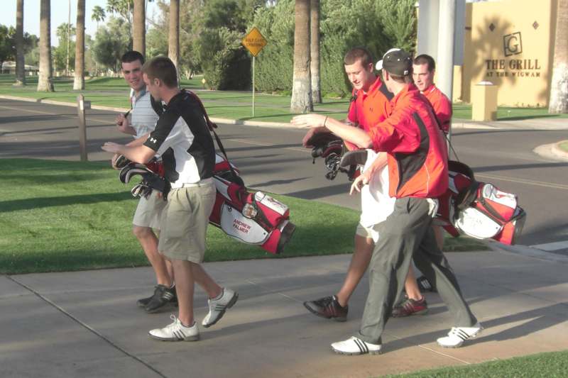 a group of men carrying golf clubs