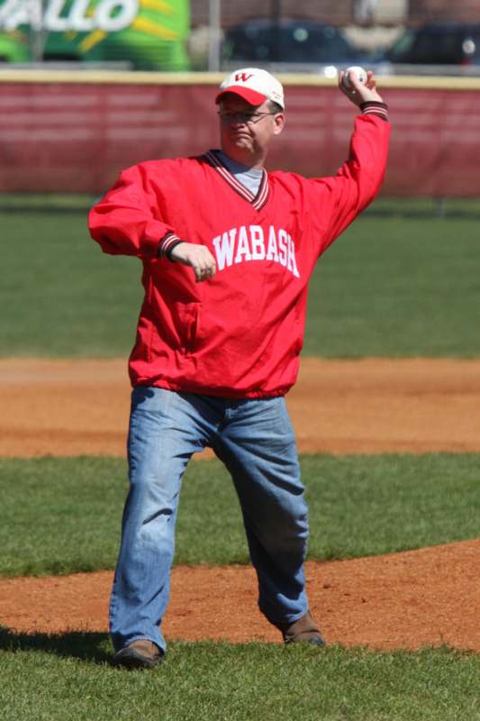 a man in a red jacket throwing a baseball