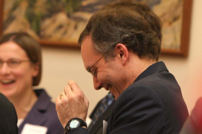 a man laughing with his hand in his mouth