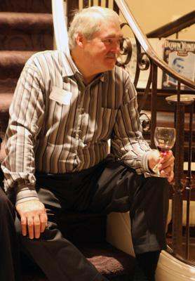 a man sitting on stairs holding a glass of wine