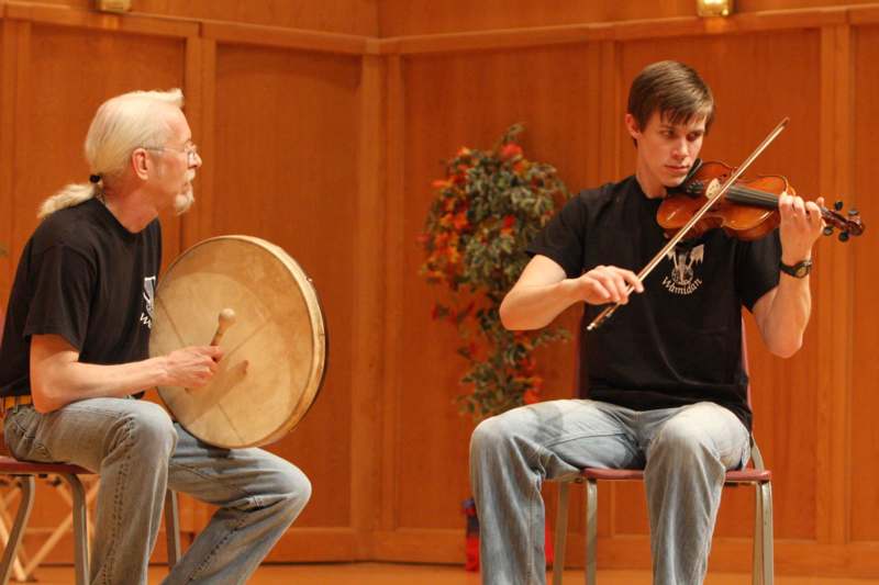 a man playing a violin and a man playing a musical instrument