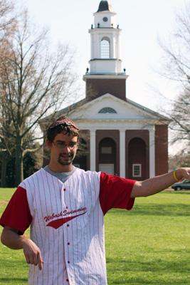 a man in a baseball uniform pointing to the side of a building