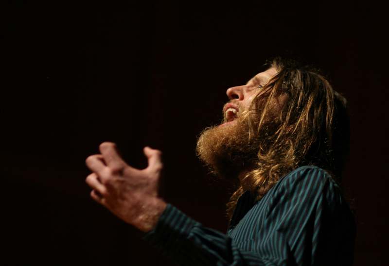 a man with long hair and beard singing