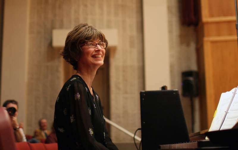 a woman smiling at a piano
