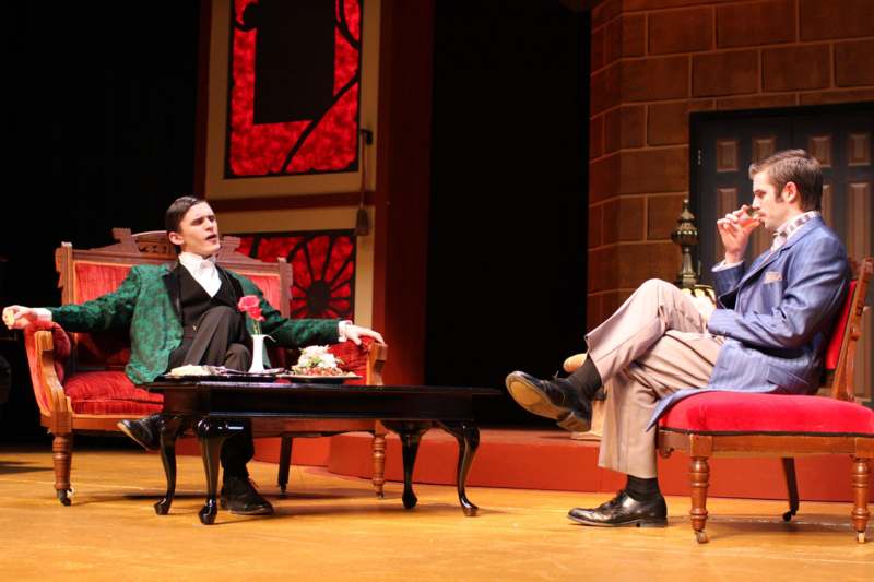 a man sitting in a chair and a woman sitting on a stage