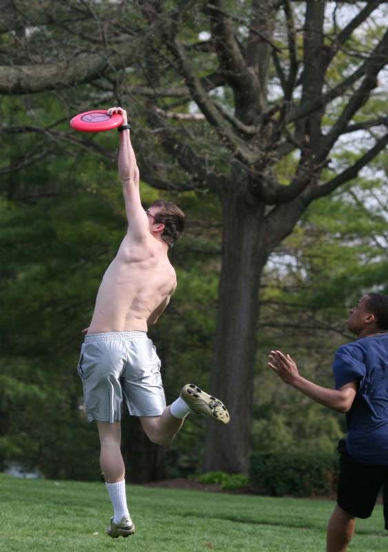 a man jumping in the air with a red frisbee
