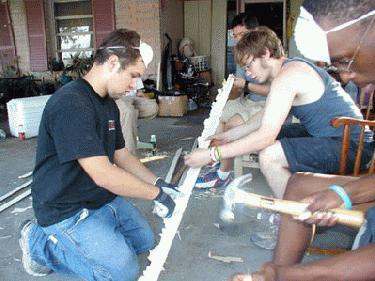 a group of men working on a piece of wood