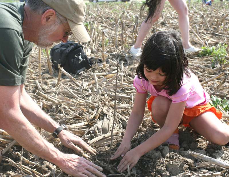 a man and a girl planting a plant