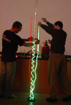 men holding up a tube with green and red lights
