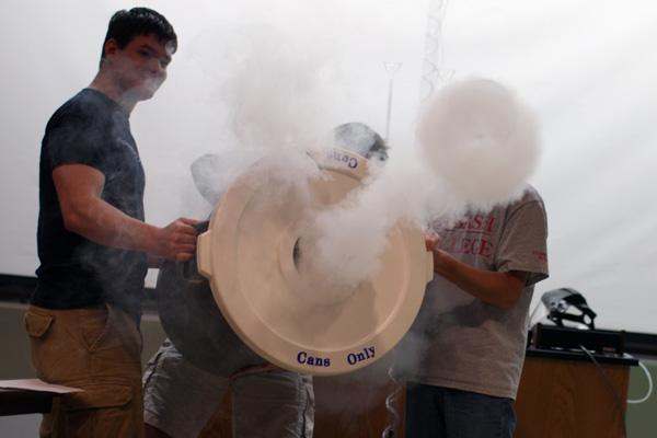 a group of men holding a large white object with smoke coming out of it
