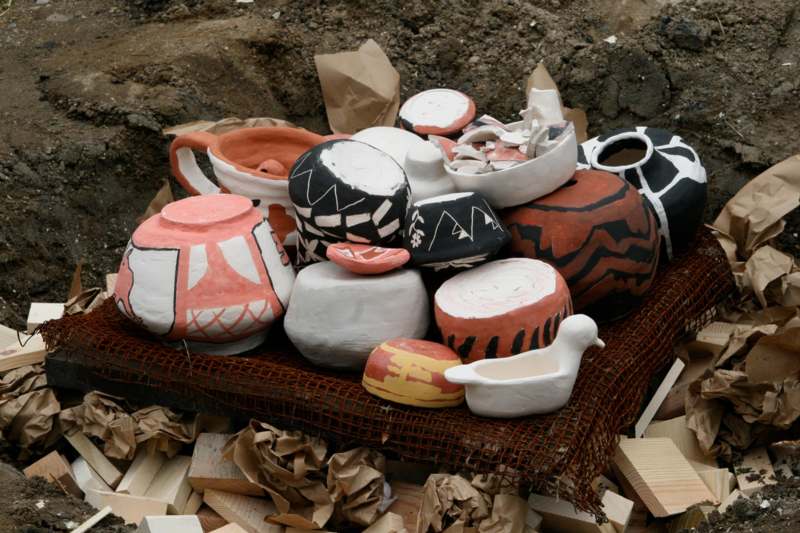 a group of pottery on a pile of wood