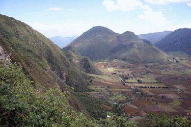 a high angle view of a valley with Pululahua Geobotanical Reserve in the background