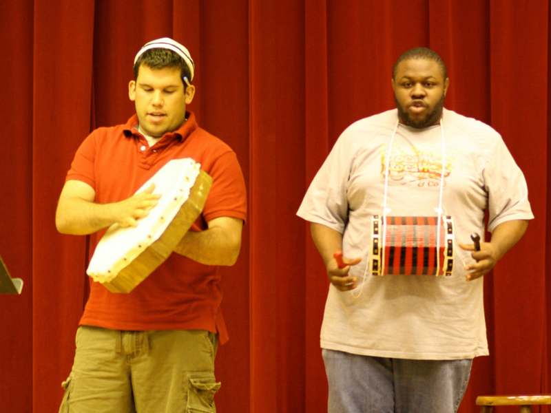 a man holding a drum and another man holding a drum