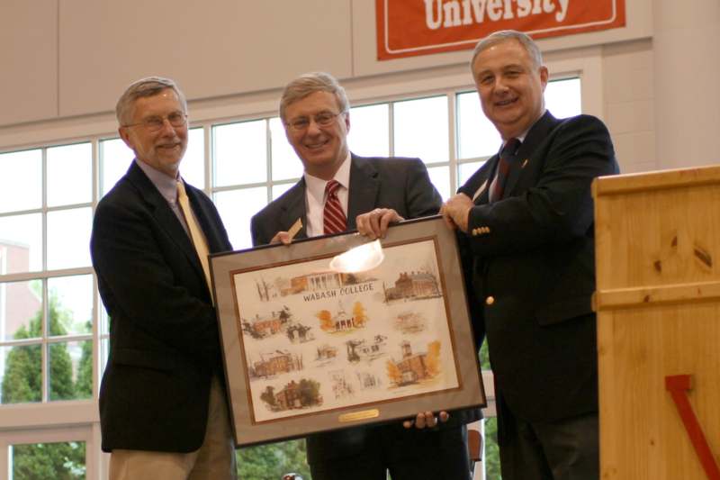 a group of men holding a framed picture