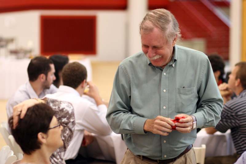a man laughing while holding a small red object