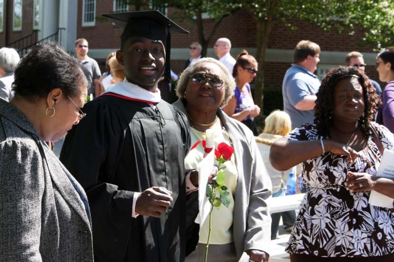 a man in a graduation cap and gown standing next to a woman