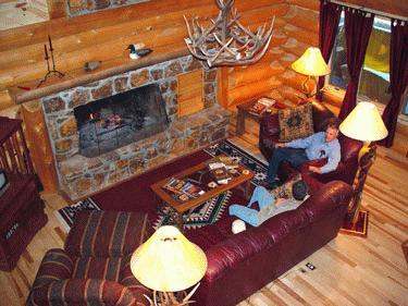 a man sitting on a couch in a log cabin