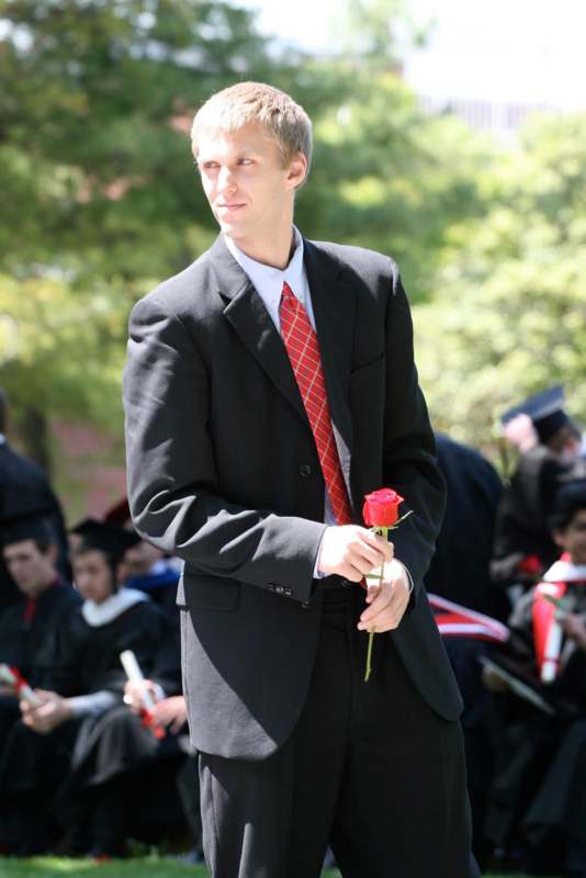 a man in a suit holding a rose