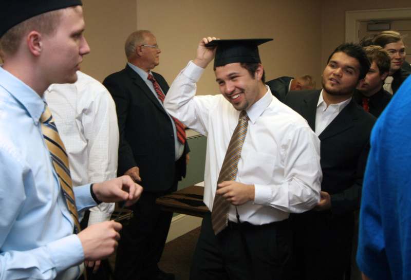 a man wearing a graduation cap and tie