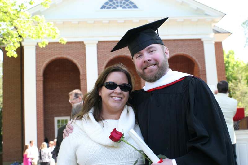 a man and woman in graduation gowns and cap