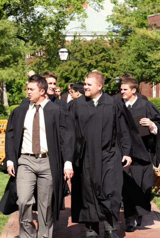 a group of men in black robes walking down a path
