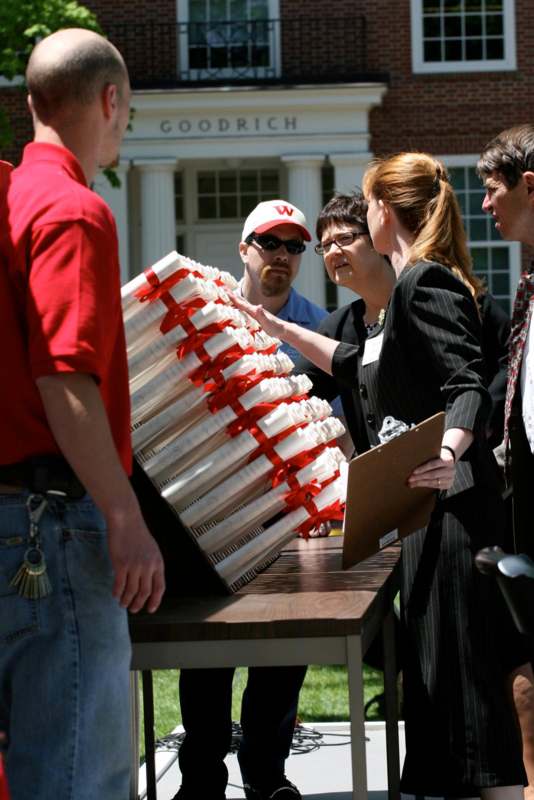 a group of people looking at a stack of white objects