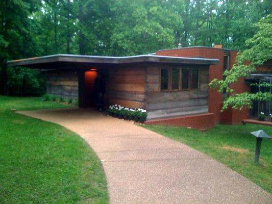 a brick building with a walkway and trees