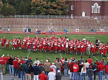 a group of people in red uniforms on a football field
