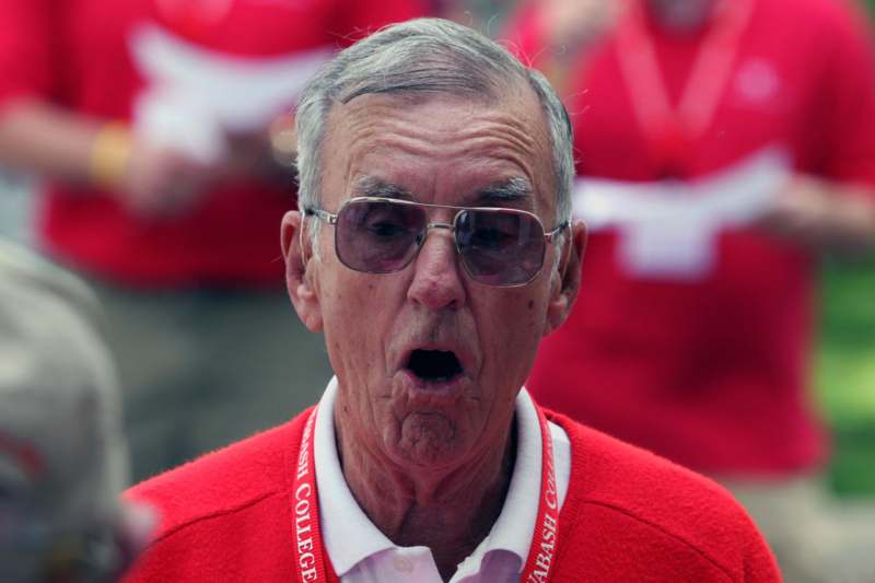 an old man wearing sunglasses and a red sweater