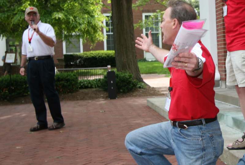 a man holding papers and standing on one knee