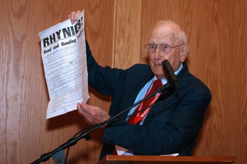an old man holding a paper in his hand