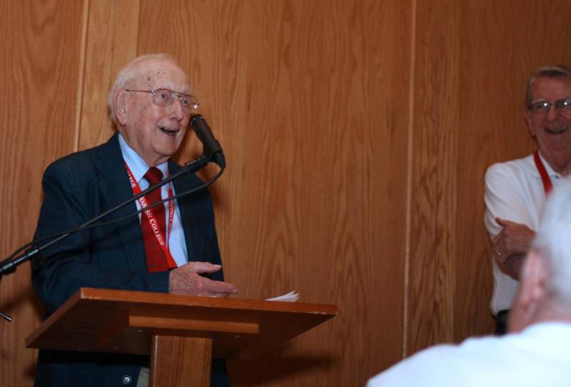 an old man speaking into a microphone