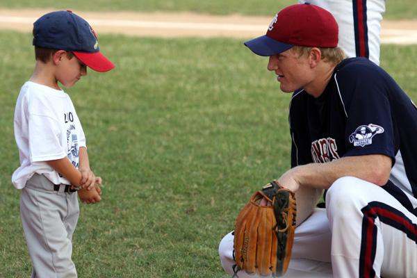 a baseball player and a young boy talking