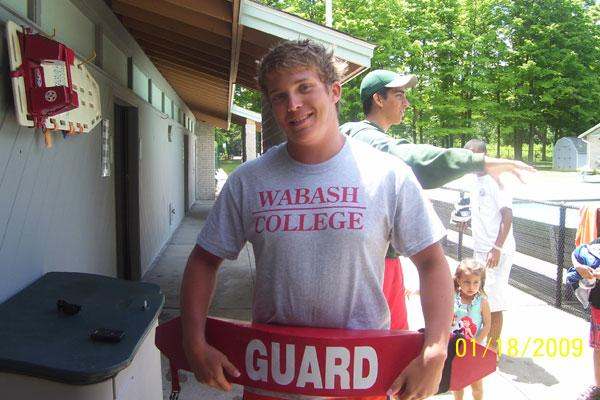a man holding a lifeguard sign