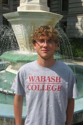 a young man standing in front of a fountain