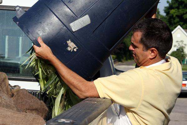 a man loading a barrel of corn
